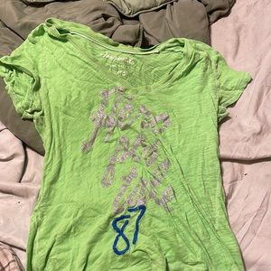 Light green shirt with sliver glitter letters on the front.